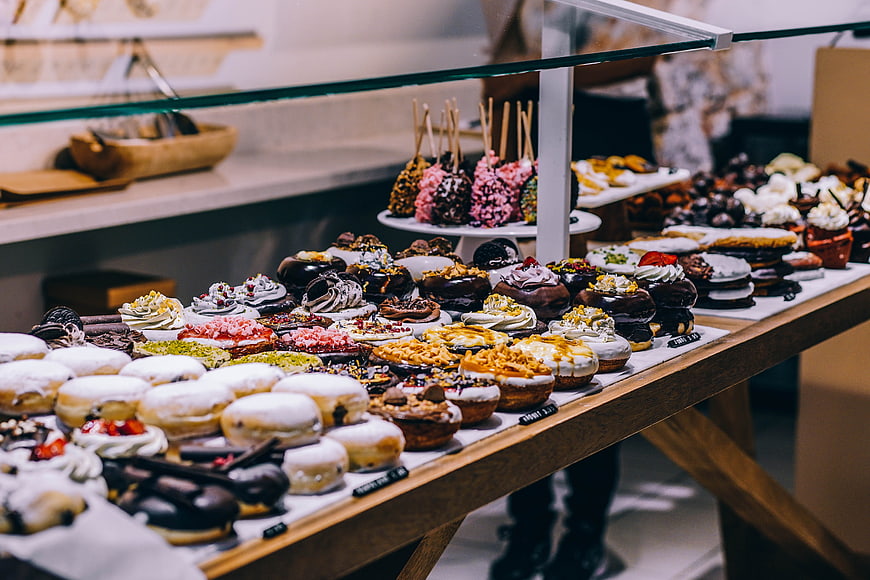 Assorted gourmet donuts and pastries in bakery display case