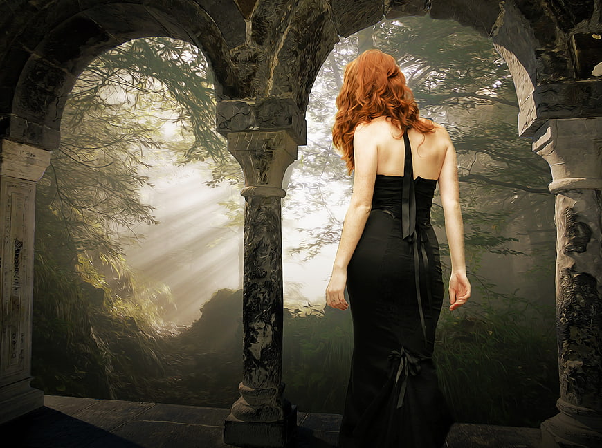 Red-haired woman in black dress standing in gothic archway