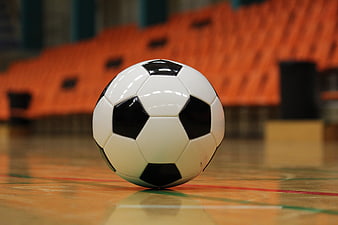 Classic black and white soccer ball on indoor sports court floor