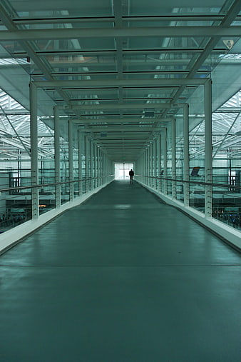 Modern airport terminal walkway with lone figure