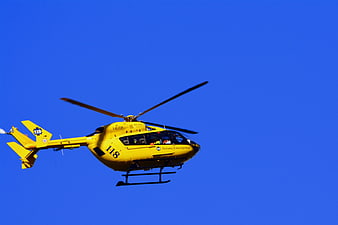 Yellow Emergency Rescue Helicopter Flying in Blue Sky