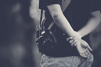 Photographer with DSLR Camera and Hands Behind Back