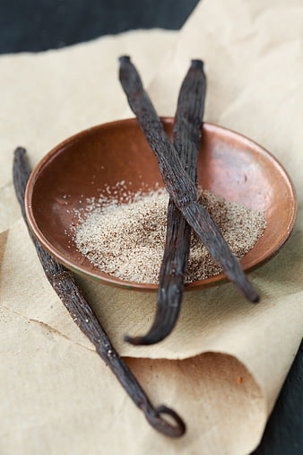 Vanilla pods and sugar in a rustic ceramic bowl