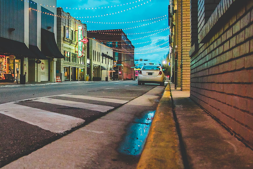 Low angle street view with string lights and neon sign