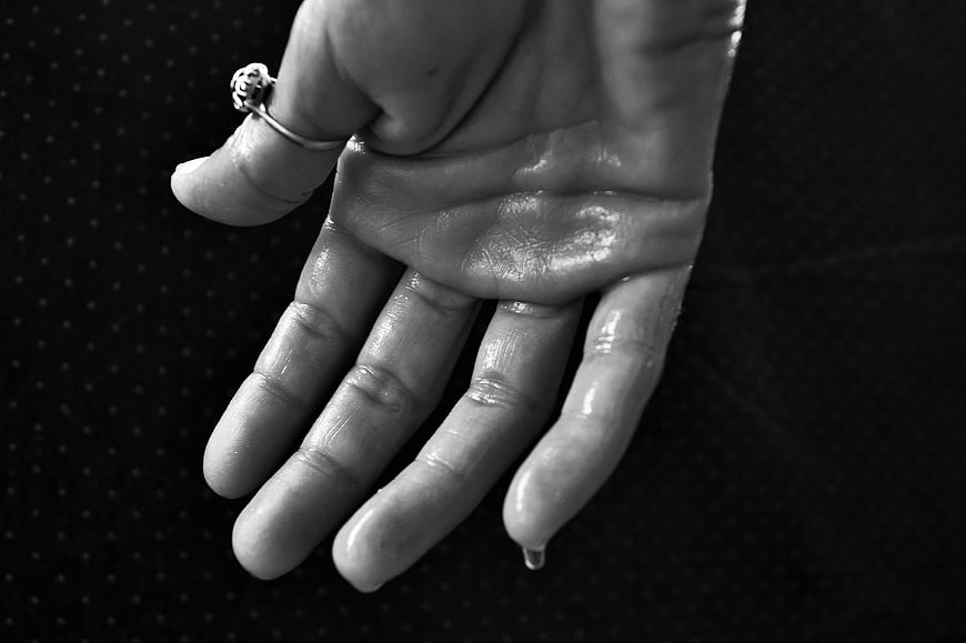 Close-up of sweaty hand with water droplet dripping