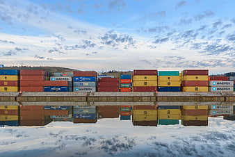 Colorful Shipping Containers Reflected in Calm Water at Port