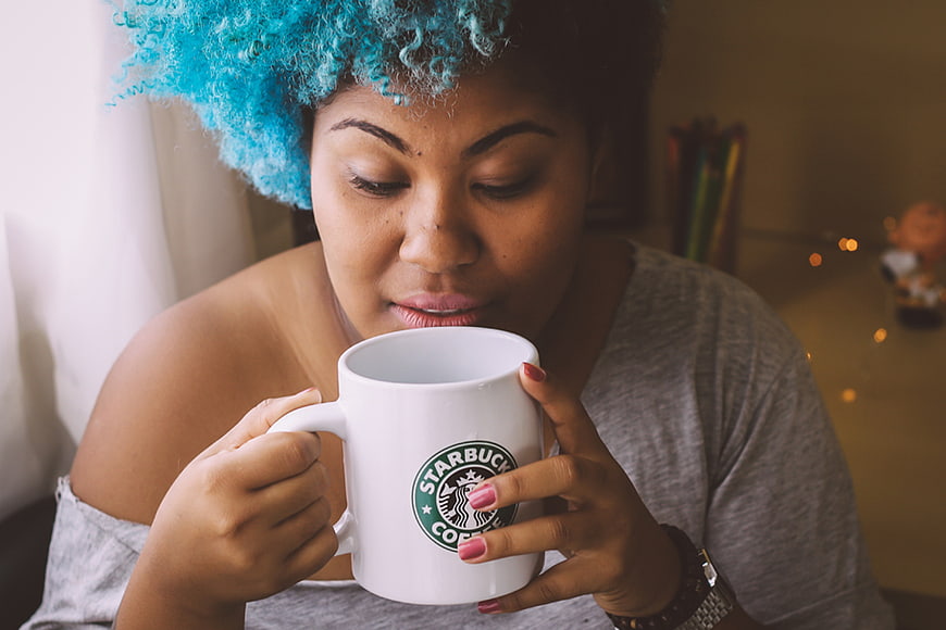 Woman with Blue Hair Sipping Coffee from White Mug