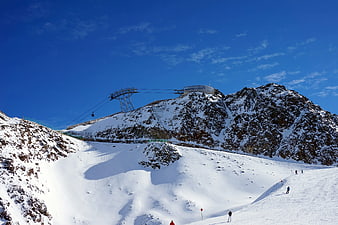 Ski resort mountain peak with cable car and snowy slopes