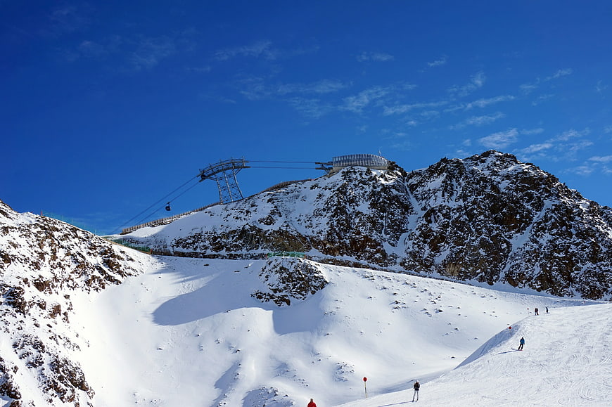 Ski resort mountain peak with cable car and snowy slopes
