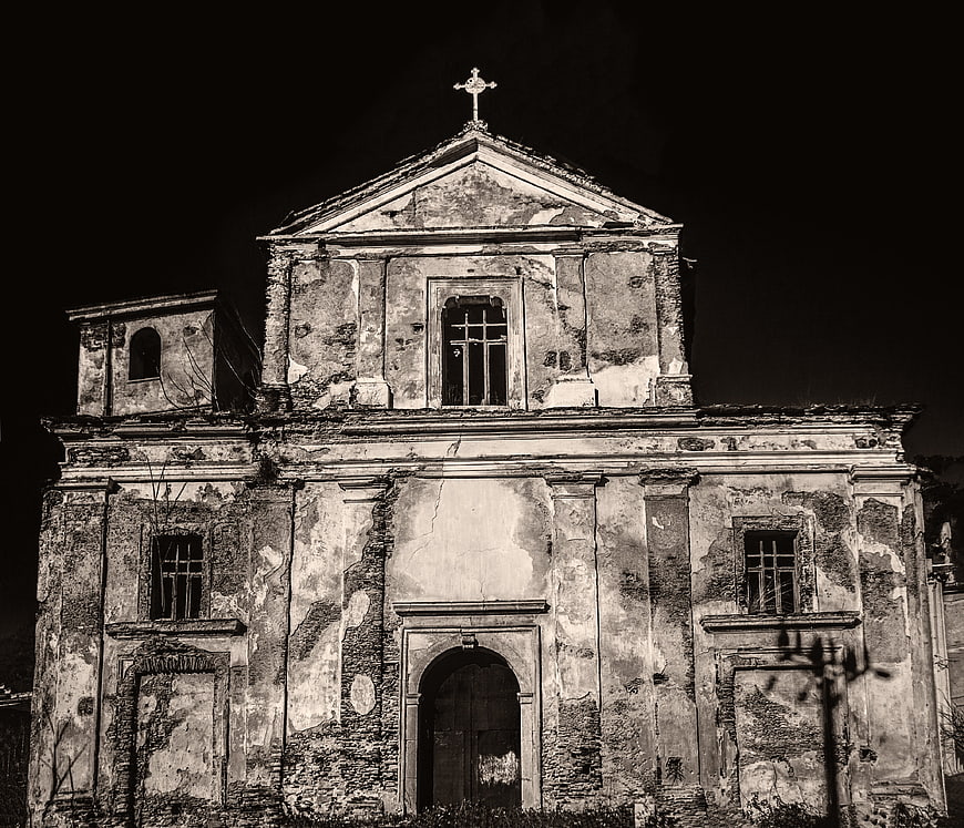 Dilapidated historic church facade in black and white