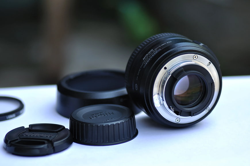 Nikon Camera Lens with Caps on White Surface