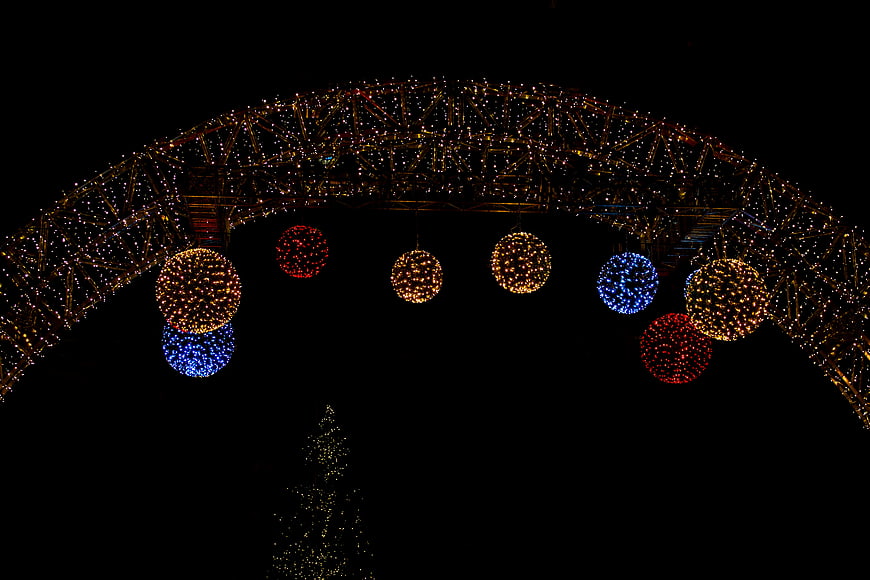 Festive Christmas Arch with Hanging Light Ornaments at Night
