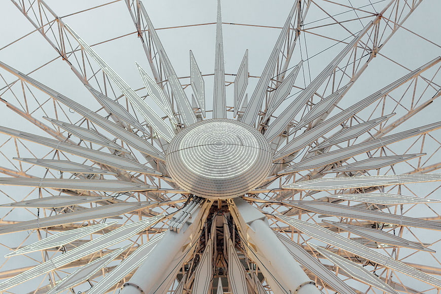 Low angle view of white Ferris wheel structure against sky