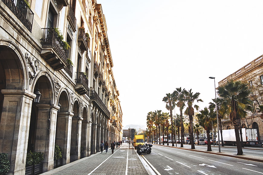 Wide Avenue with Arched Architecture and Palm Trees