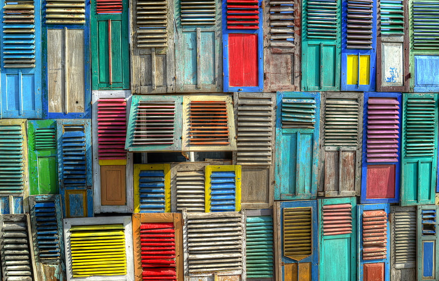 Colorful vintage wooden shutters on a weathered building facade