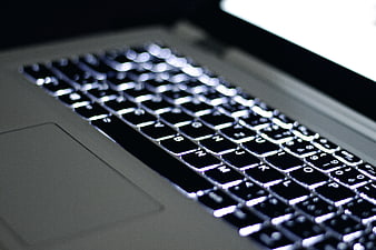 Close-up of laptop keyboard with backlit keys and trackpad