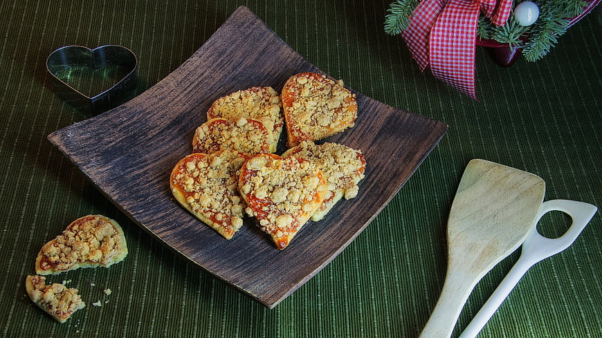 Heart-Shaped Christmas Cookies on Wooden Plate with Holiday Decor