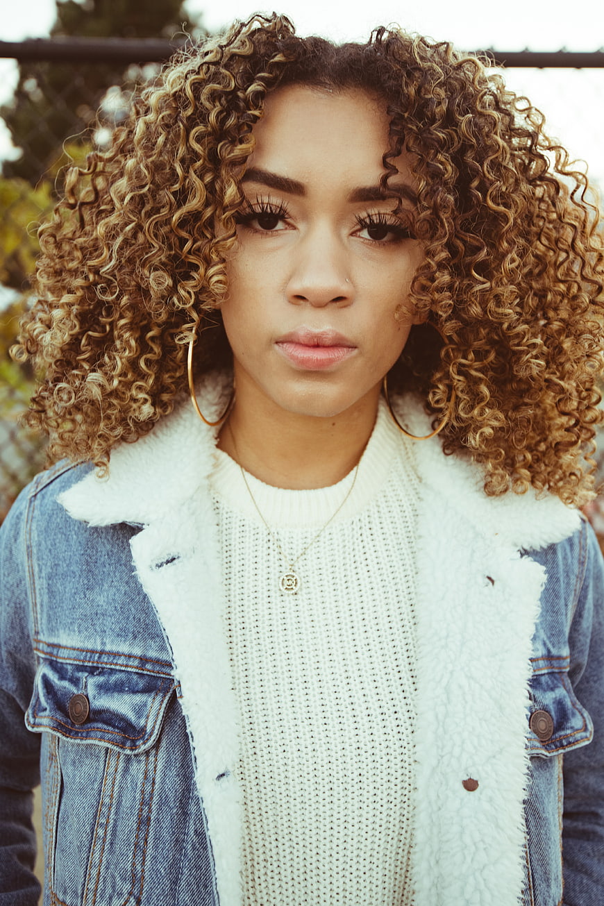 Portrait of Woman with Curly Blonde Hair and Denim Jacket