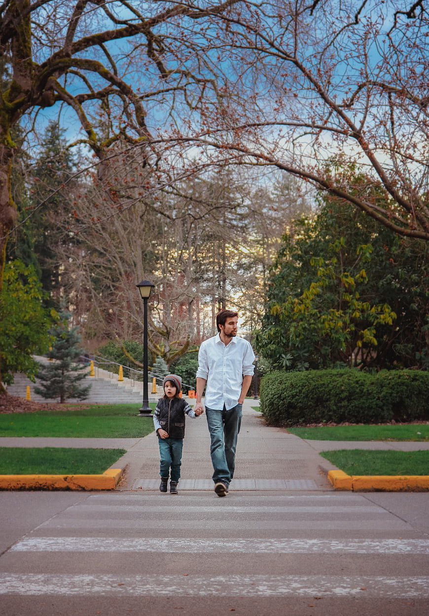 Father And Young Son Walking Together In Park