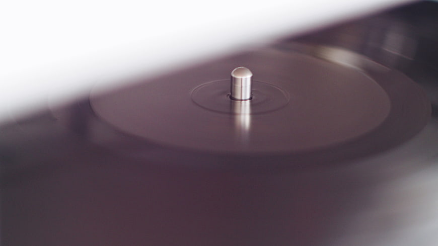 Close-up of spinning vinyl record on turntable spindle