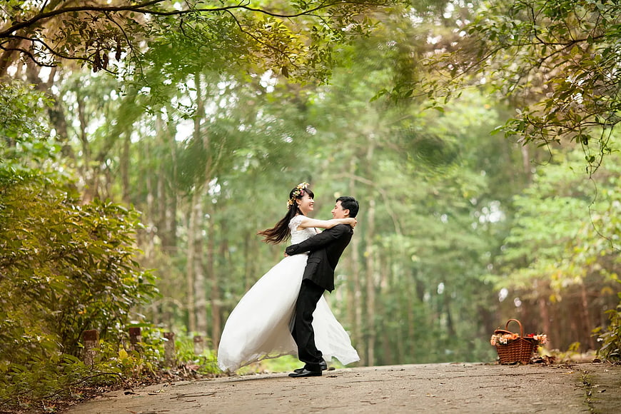 Happy Wedding Couple Spinning in Forest