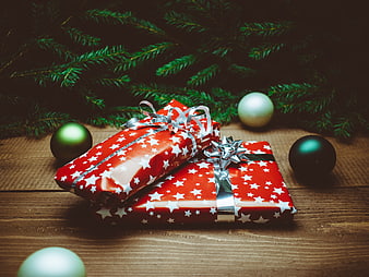 Christmas gifts wrapped in red star paper with ornaments