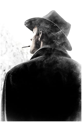 Black and white portrait of a man in a fedora smoking a cigarette