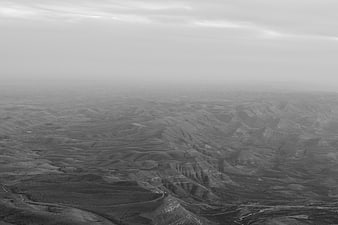 Black and white aerial view of vast hilly landscape