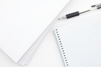 Minimalist white workspace with notebook and pen