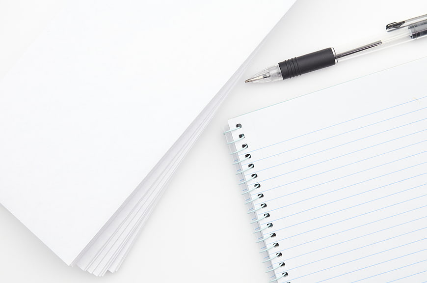 Minimalist white workspace with notebook and pen