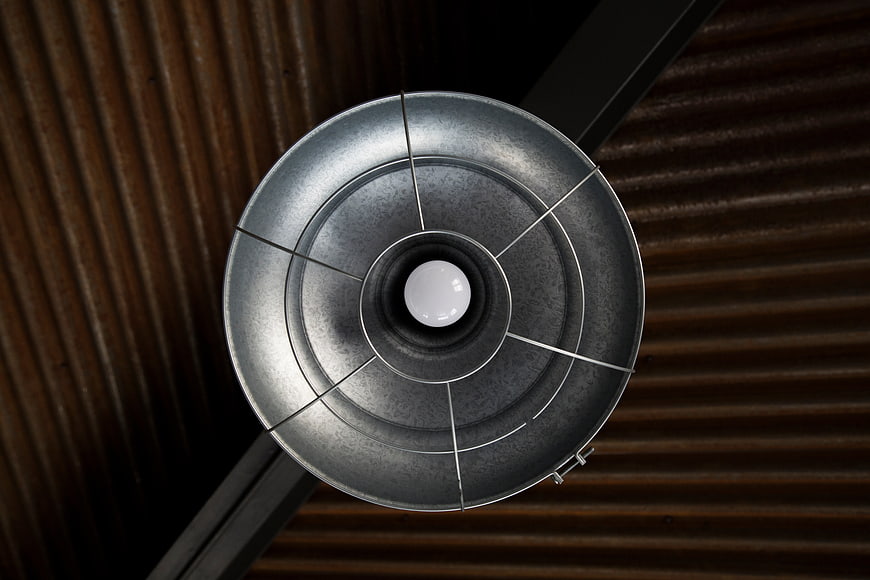 Industrial metal ceiling light fixture with corrugated background