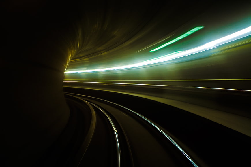 Abstract motion blur of subway train tracks in a dark tunnel
