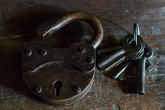 Vintage Rusty Padlock and Old Keys on Wooden Surface