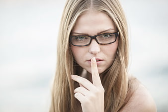 Young Woman With Glasses Making Shushing Gesture