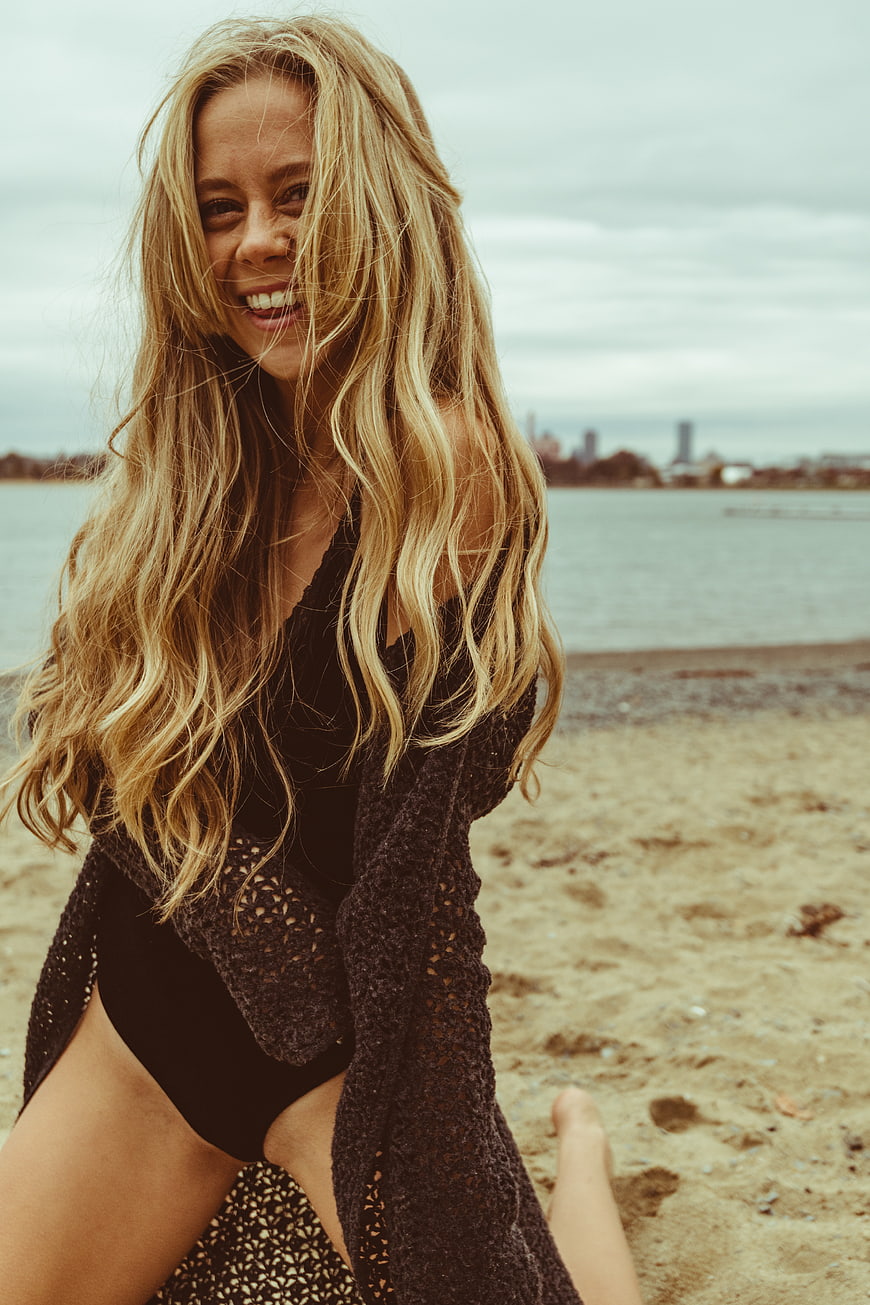 Happy Blonde Woman Laughing on Sandy Beach