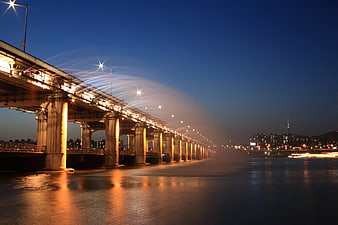 Night long exposure of concrete bridge with sprinkler water arcs