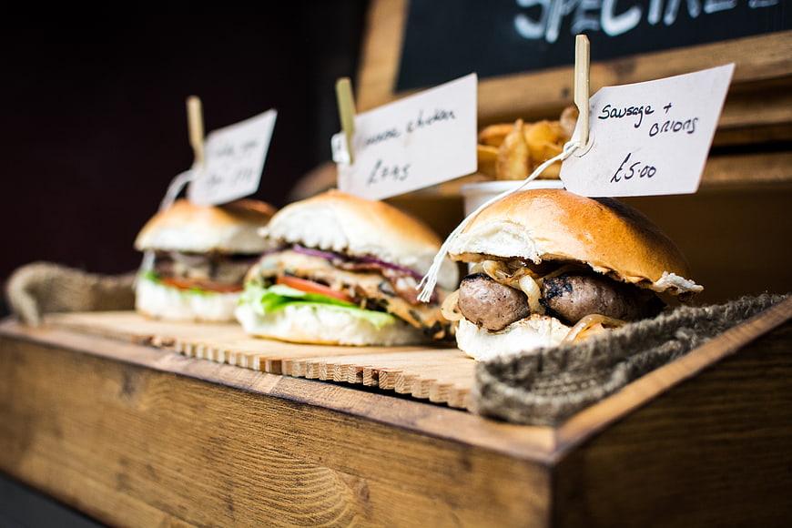 Gourmet sausage and chicken sliders on wooden board