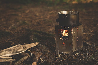 Portable camping stove with pot cooking in forest