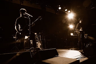 Rock band performing live on stage with dramatic lighting