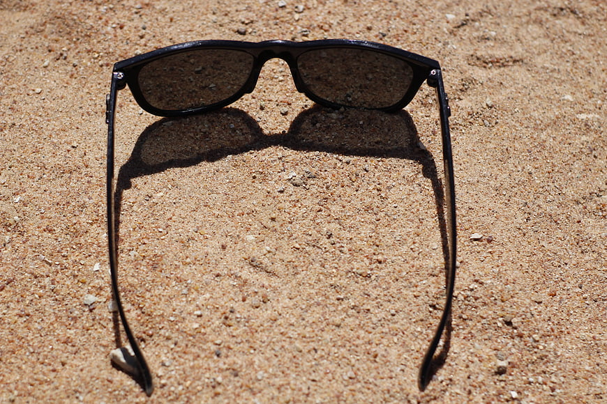 Black Sunglasses on Sand Beach Summer