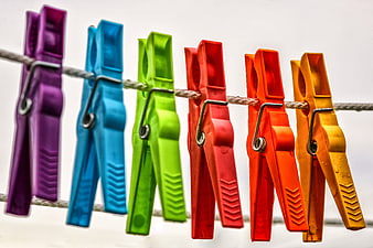 Colorful Plastic Clothespins Hanging On A Rope Against White Background