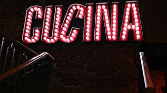 Retro Red Marquee Sign Reading Cucina on Brick Wall