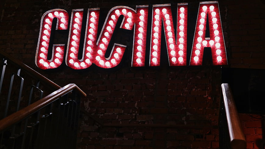 Retro Red Marquee Sign Reading Cucina on Brick Wall