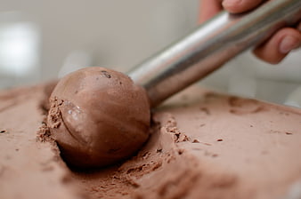 Close-up of chocolate ice cream being scooped with metal utensil