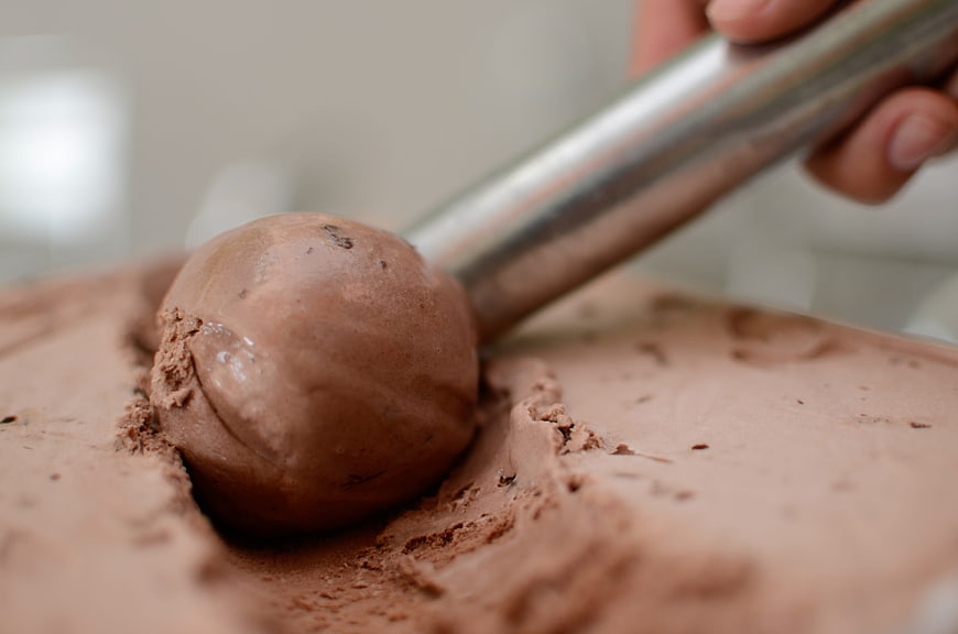 Close-up of chocolate ice cream being scooped with metal utensil