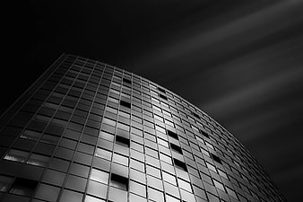 Low-angle black and white skyscraper with dramatic sky