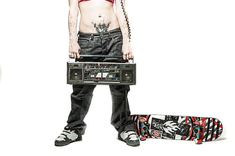 Woman with tattoos holding boombox and skateboard