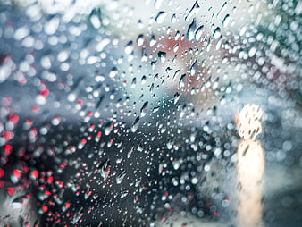 Raindrops on Glass Window with Blurred City Lights