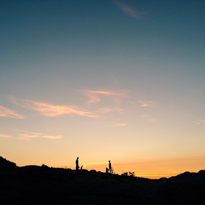 Silhouette of people on a hilltop at sunset