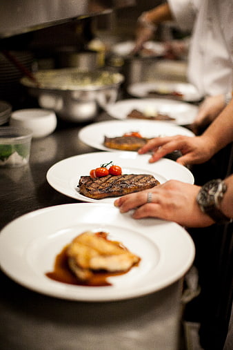 Chef Plating Gourmet Steak in Professional Kitchen